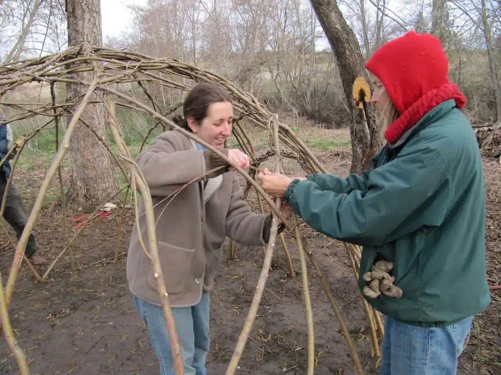 Libby VanWyhe and Linda Chesney working together on creating the Living Willow Hut.