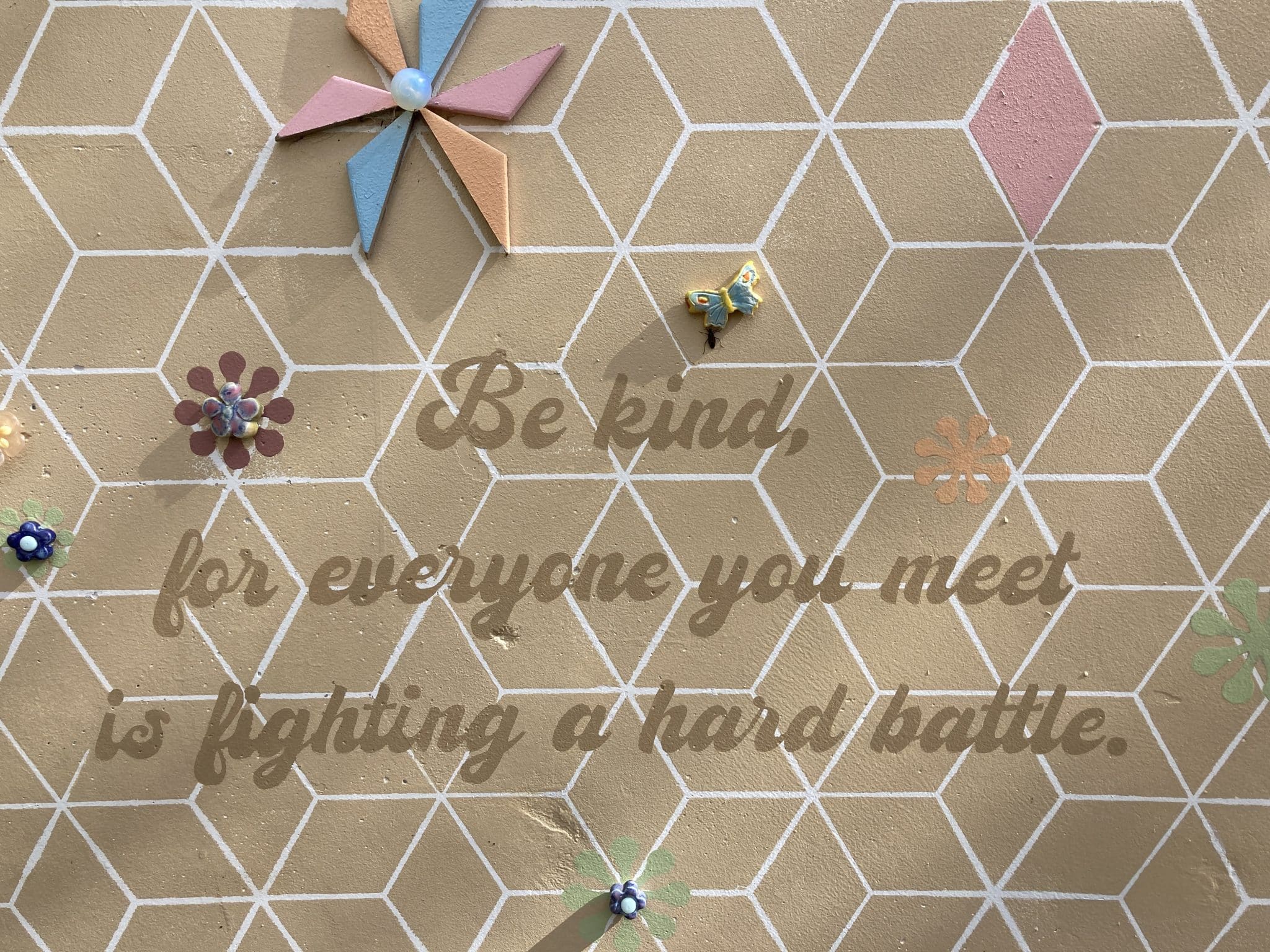 A saying in the Palm Motel mosaic courtyard: "Be kind, for everyone you meet is fighting a hard battle."