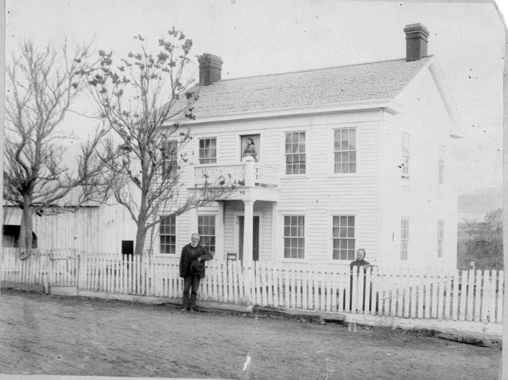Giles and Martha Wells in front of their house, Sarah Murray on balcony, no date. (SOHS photo #2333)