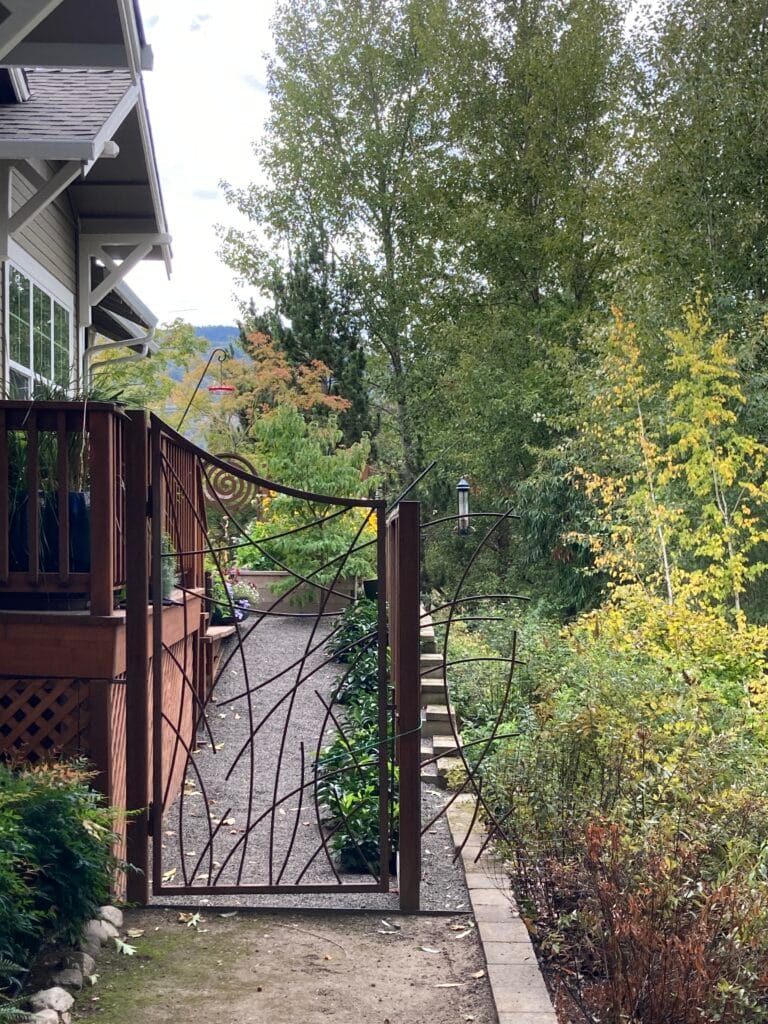 An artistic steel gate entrance to the side yard, along Kitchen Creek, at 735 Meadowlark Way.