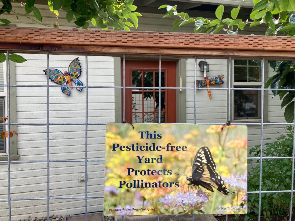 Here's a pretty pollinator garden sign, with colorful pollinator art, on South Alley.