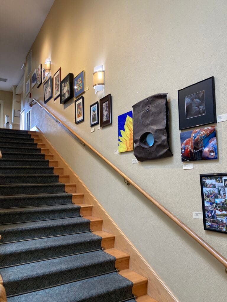 This "Staircase Gallery" in the Clubhouse features art by residents of Mountain Meadows.