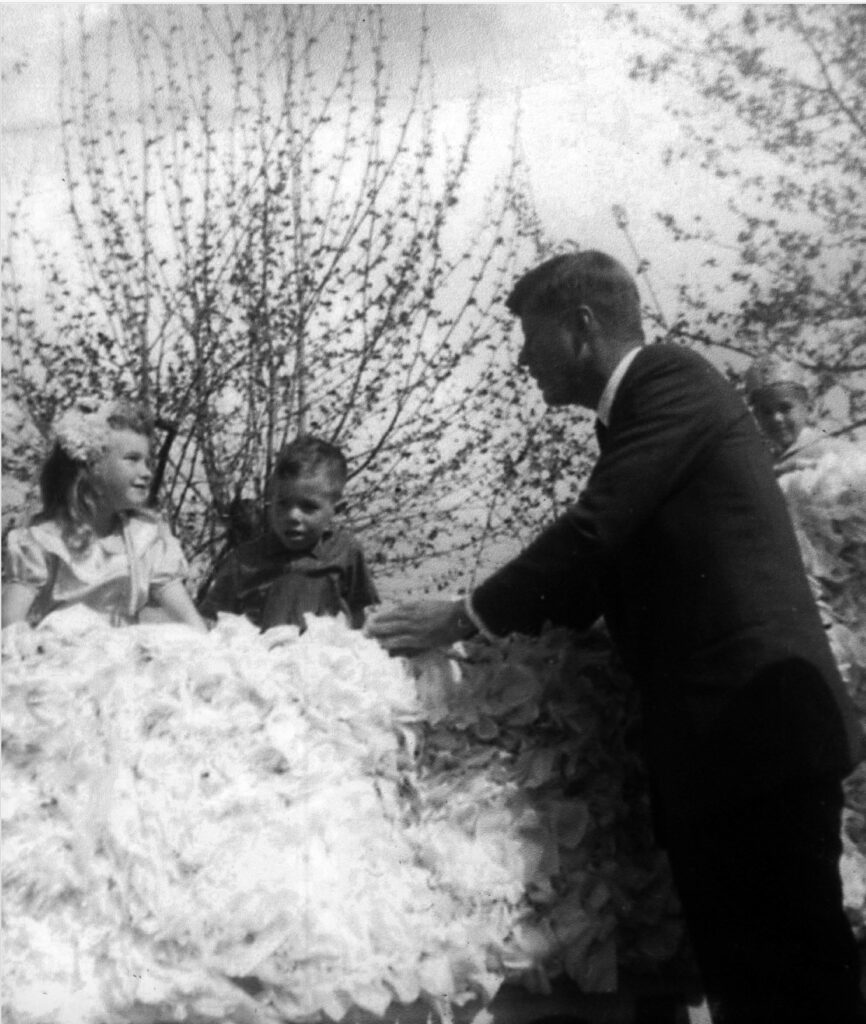 Senator John Kennedy at 1960 Medford Pear Blossom Parade, greeting young children. (photo SOHS 85180)