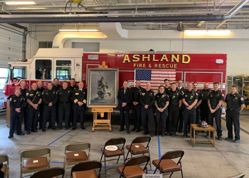 Ashland firefighters celebrate receiving the original painting "A Prayer for My Brother" from artist and former Ashland firefighter William S. Phillips, Sept. 11, 2026. From the viewer's perspective, Phillips is to the right of the painting and Chief Rasor to the left.