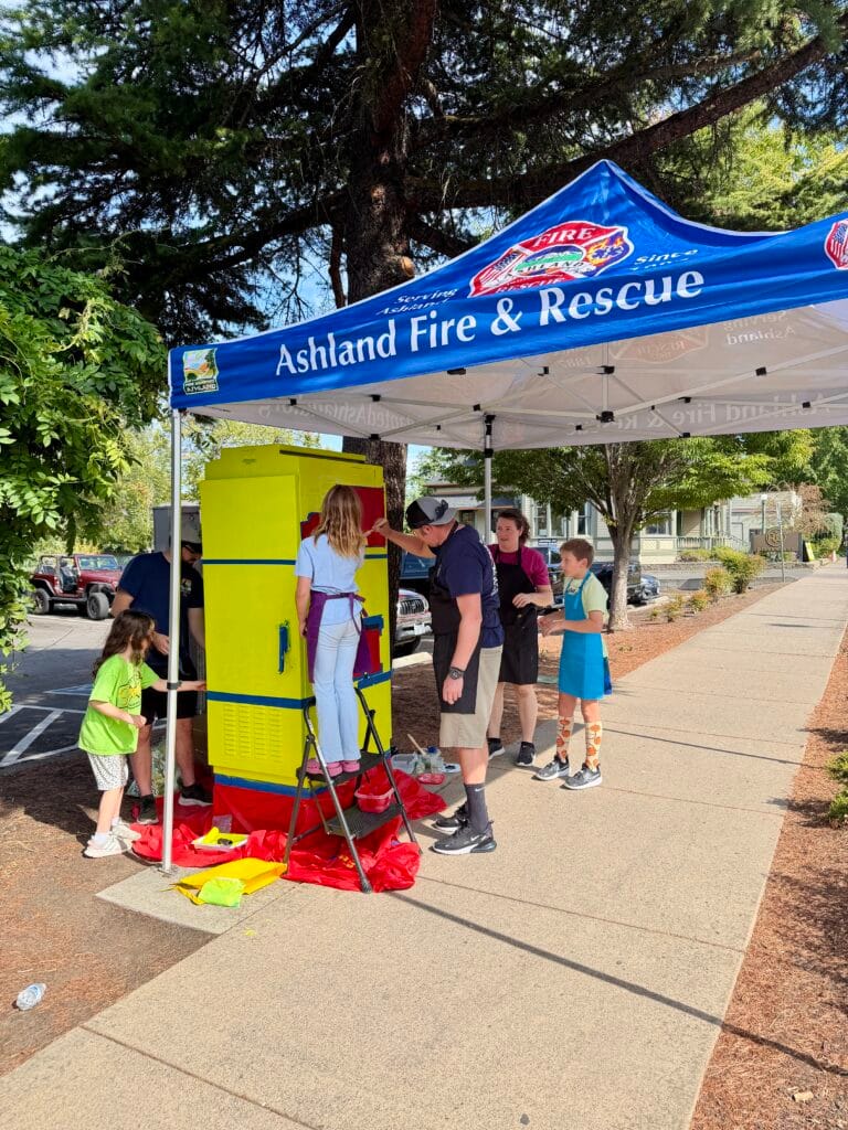 Battalion Chief Nick Palmesano is helping paint the traffic signal box: "Fire Engine and Ambulance," early in the first day of painting.