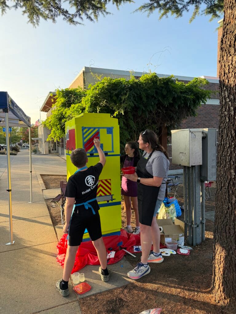 Katie and her children are painting the traffic signal box: "Fire Engine and Ambulance," near the end of the first day of painting.