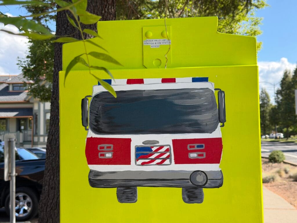 Traffic signal box: "Fire Engine and Ambulance." Artist Glory Nylander. Front of Ashland fire engine, with American flag graphic.